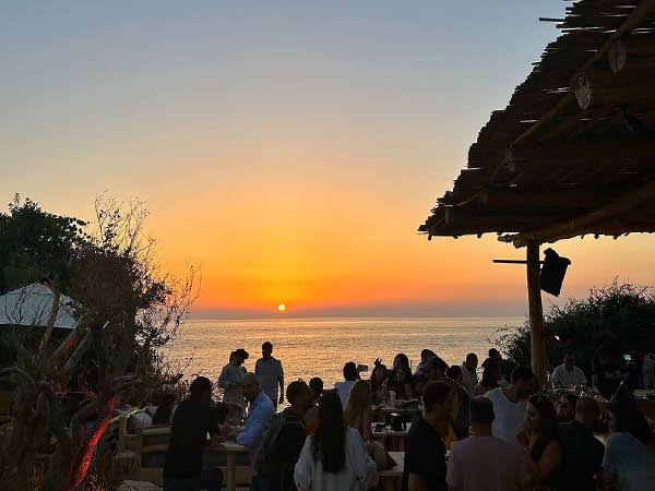 A beach gathering at sunset in Batroun